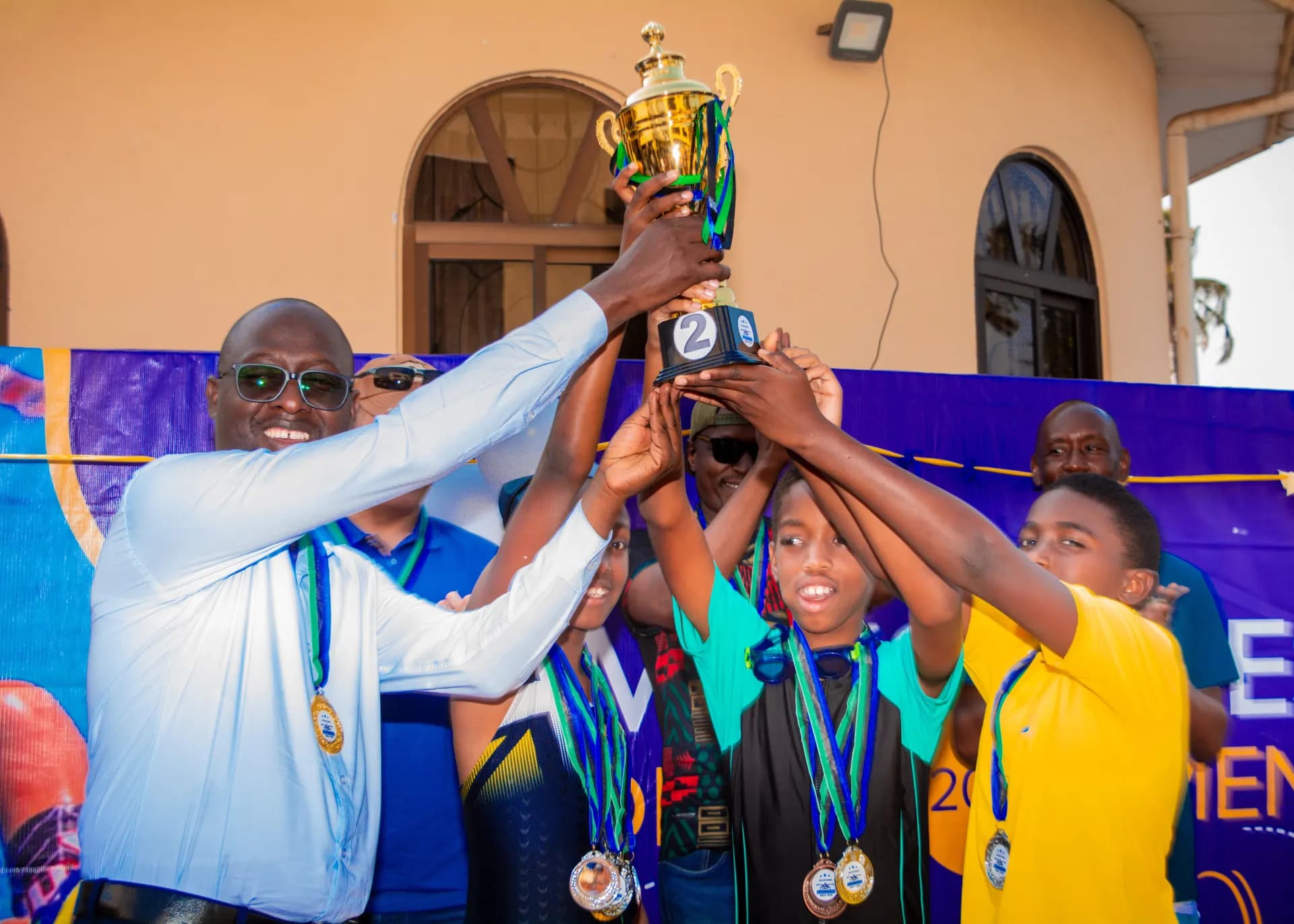 A team celebrates with its swimming trophy.